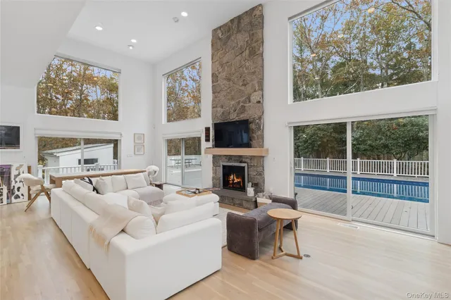 a living room with furniture a fireplace and a large window