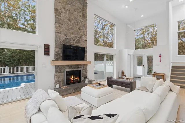 a living room with furniture large window and fireplace