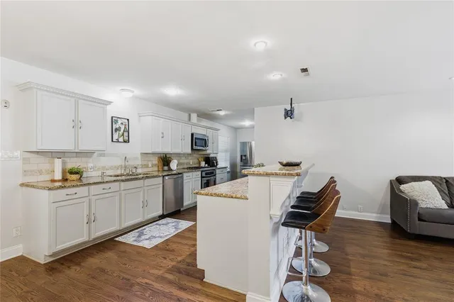 a kitchen with a sink a stove a refrigerator dining table and chairs