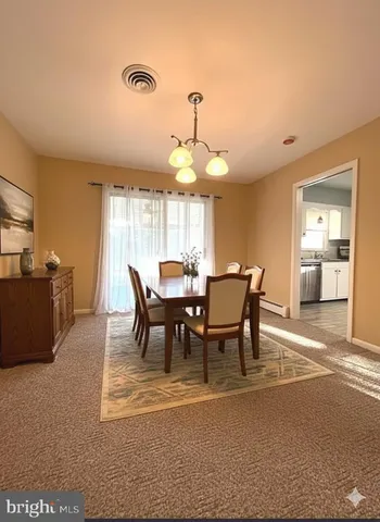 a view of a a dining room with furniture window and wooden floor