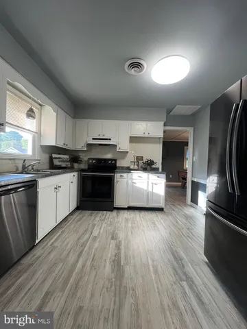 a kitchen with granite countertop a sink and stainless steel appliances