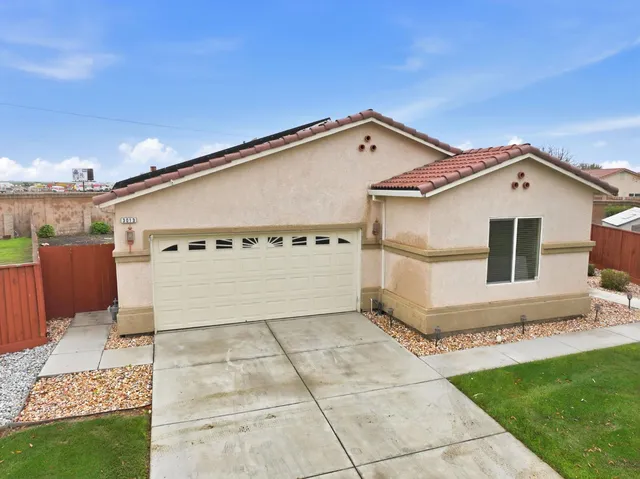 a backyard of a house with table and chairs