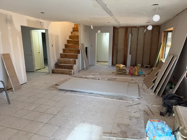 a view of a entryway door with stairs and a living room