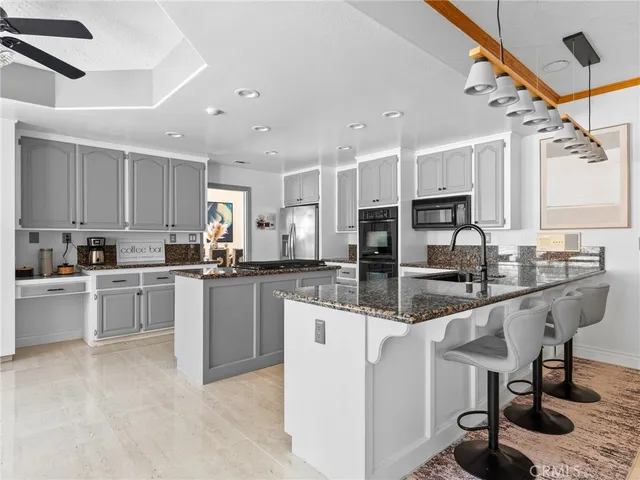 a spacious bedroom with a bed a chandelier and glass door