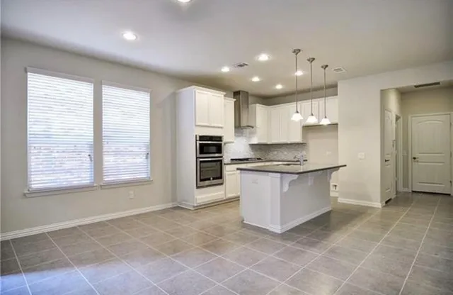 a large kitchen with kitchen island granite countertop a window and a sink