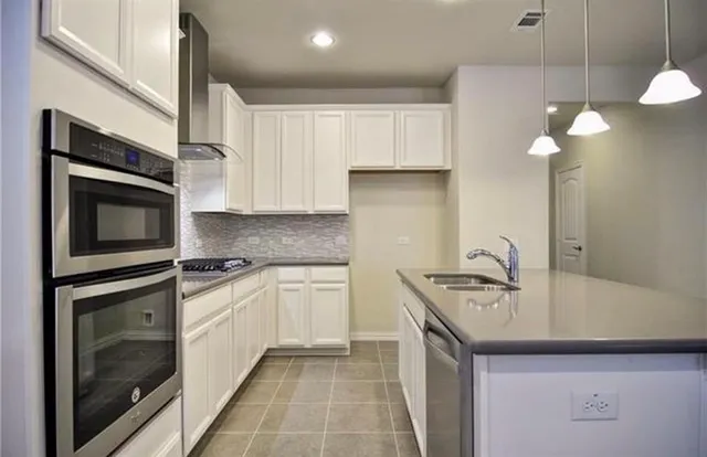 a kitchen with stainless steel appliances granite countertop a sink a stove and cabinets