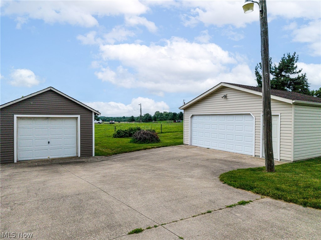 9626 Daniels Road Seville, OH 44273 - Photo 6 of 37 Two detached garages featuring vinyl siding, white garage doors, and shingle roofs