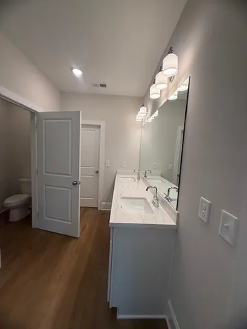 a bathroom with a sink a toilet and mirror
