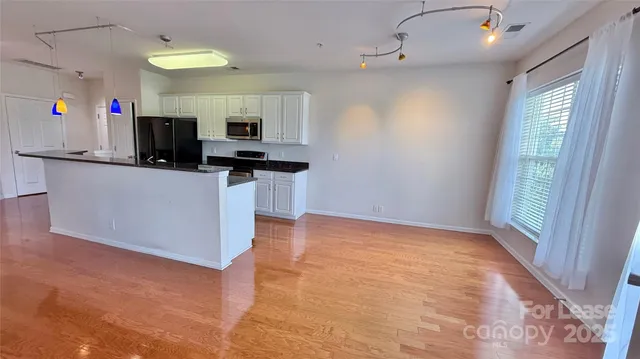 a kitchen with stainless steel appliances granite countertop a sink a stove top oven a counter space and cabinets