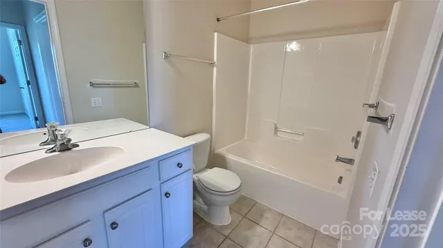 a bathroom with a sink a toilet and a large mirror