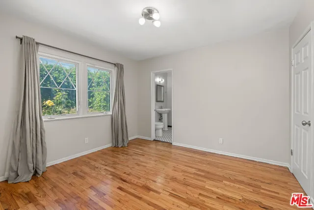 a view of backyard with large tree and wooden fence