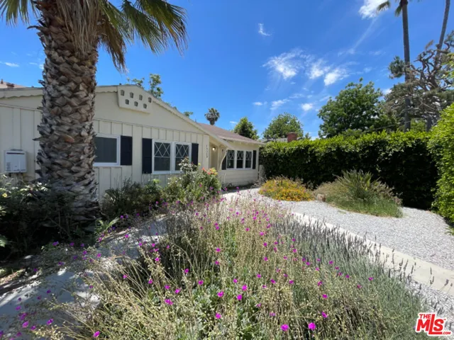 an empty room with wooden floor fireplace and windows