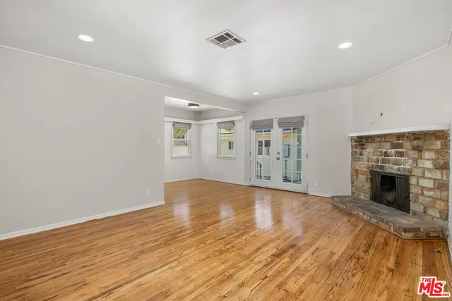a view of empty room with wooden floor and fireplace