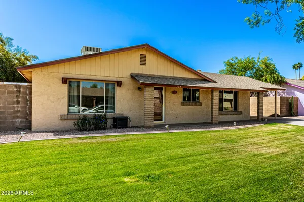a view of a house with a yard and sitting area