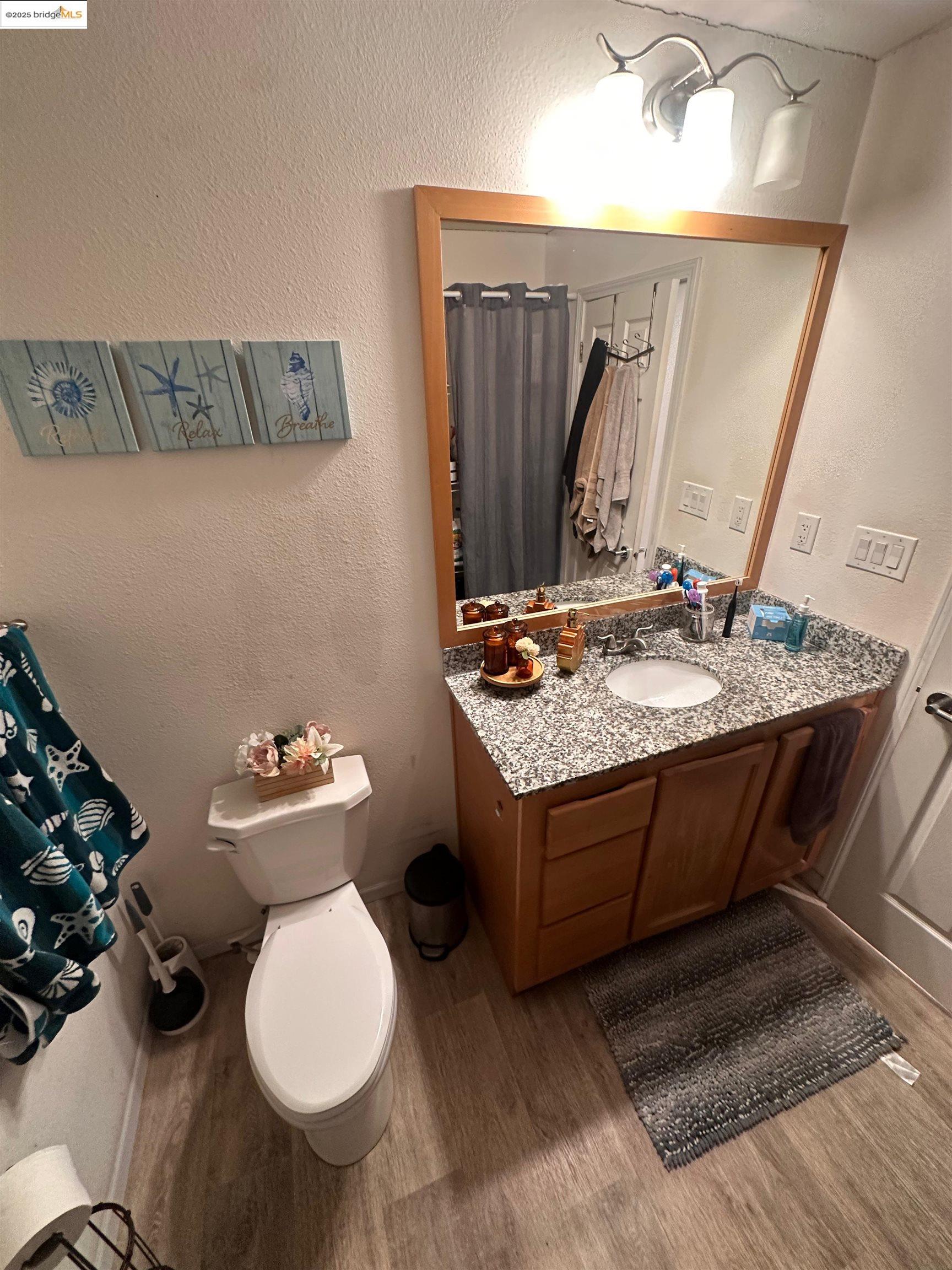 55 Pacifica Avenue, Unit 49 Bay Point, CA 94565 - Photo 7 of 12 a bathroom with a toilet sink and mirror