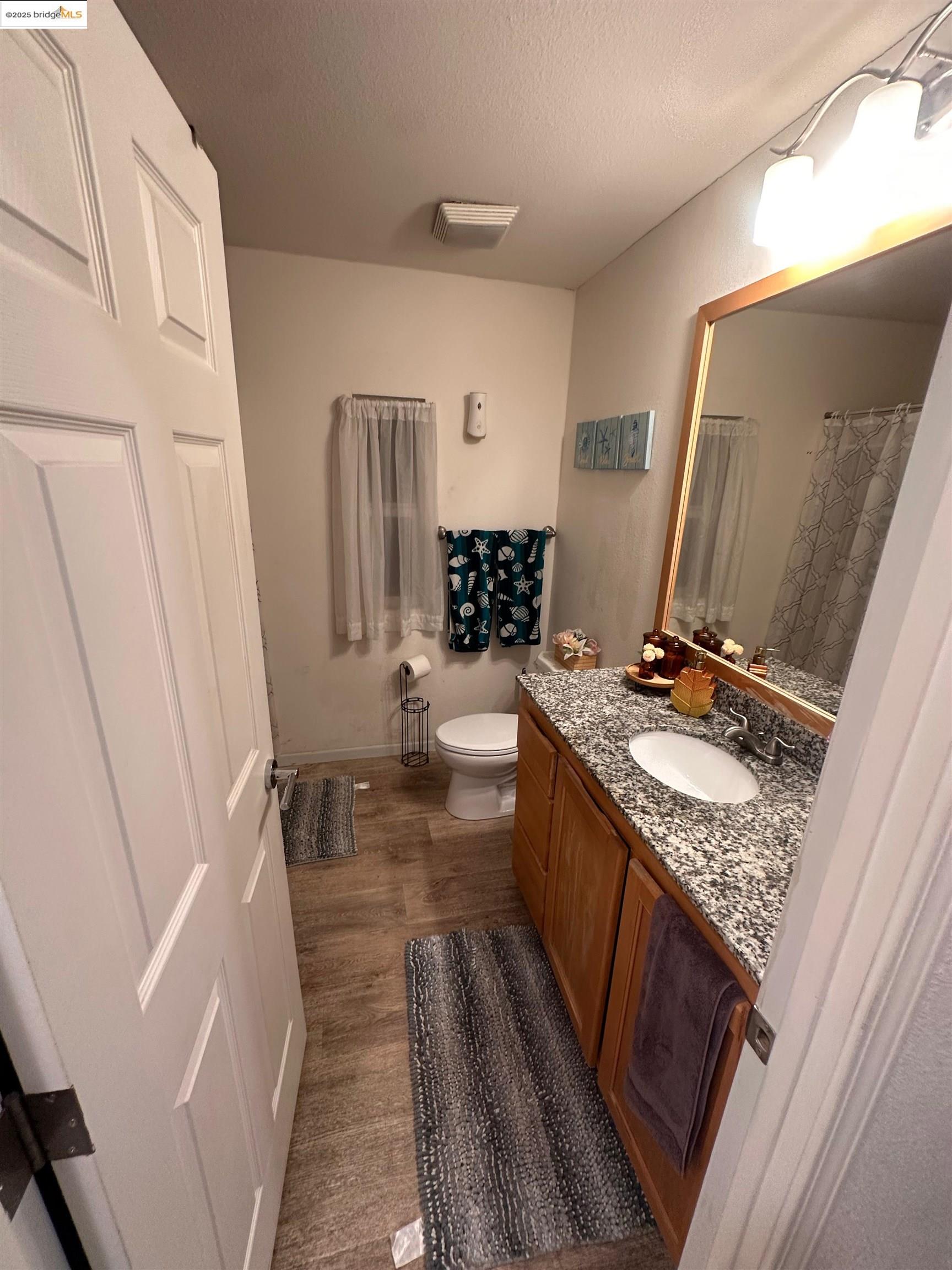 55 Pacifica Avenue, Unit 49 Bay Point, CA 94565 - Photo 10 of 12 a bathroom with a granite countertop sink and a mirror