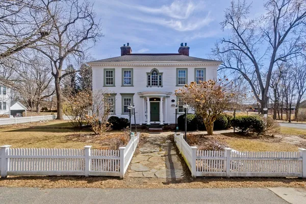 a front view of a house with a yard covered with snow