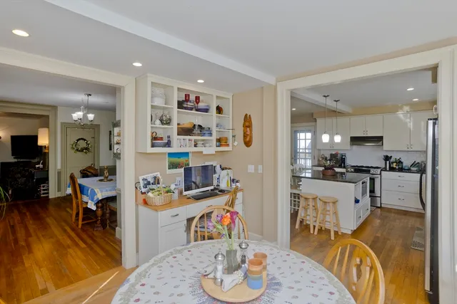 a kitchen with stainless steel appliances wooden floor dining table and chairs