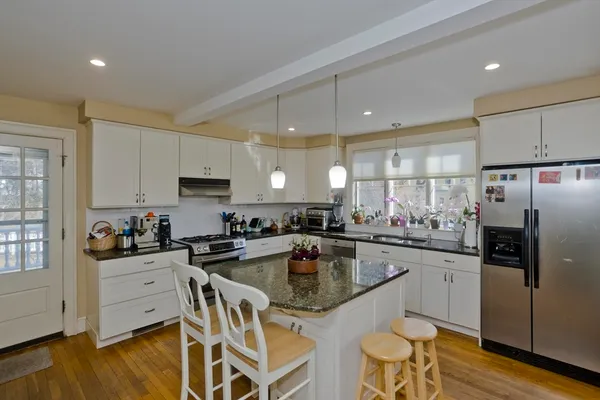 a kitchen with granite countertop a sink stove and refrigerator