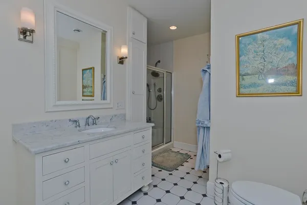 a bathroom with a granite countertop sink toilet and shower