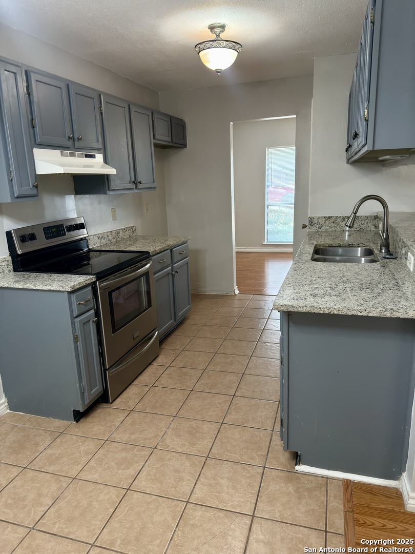 7334 Mystery Ridge Drive Converse, TX 78109 - Photo 10 of 26 a kitchen with stainless steel appliances granite countertop a sink stove and cabinets