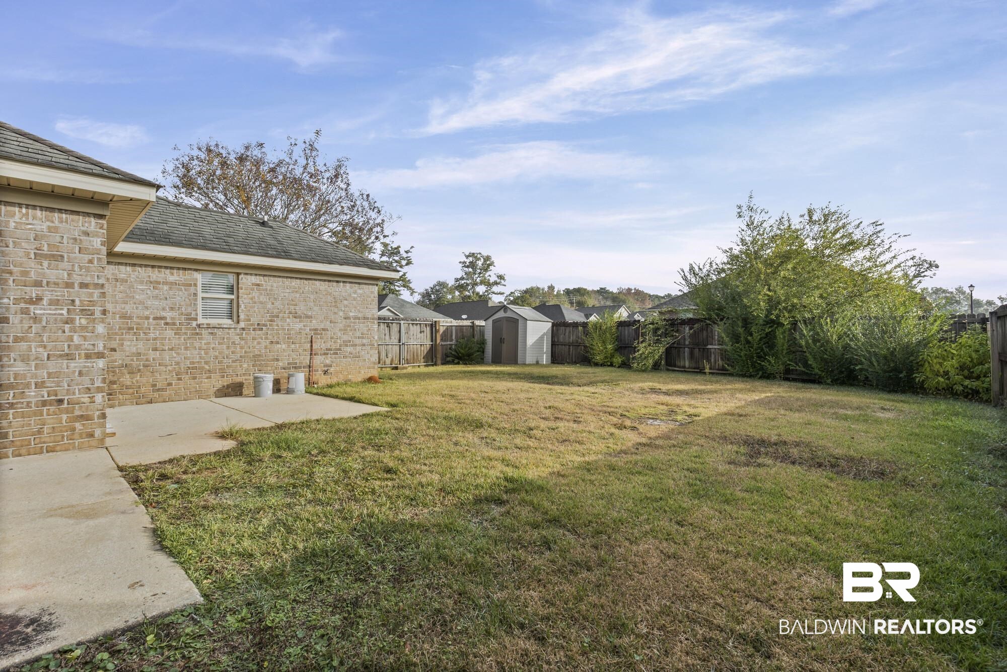 2084 Redpine Drive Semmes, AL 36575 - Photo 17 of 22 Fenced backyard with a storage unit and a patio