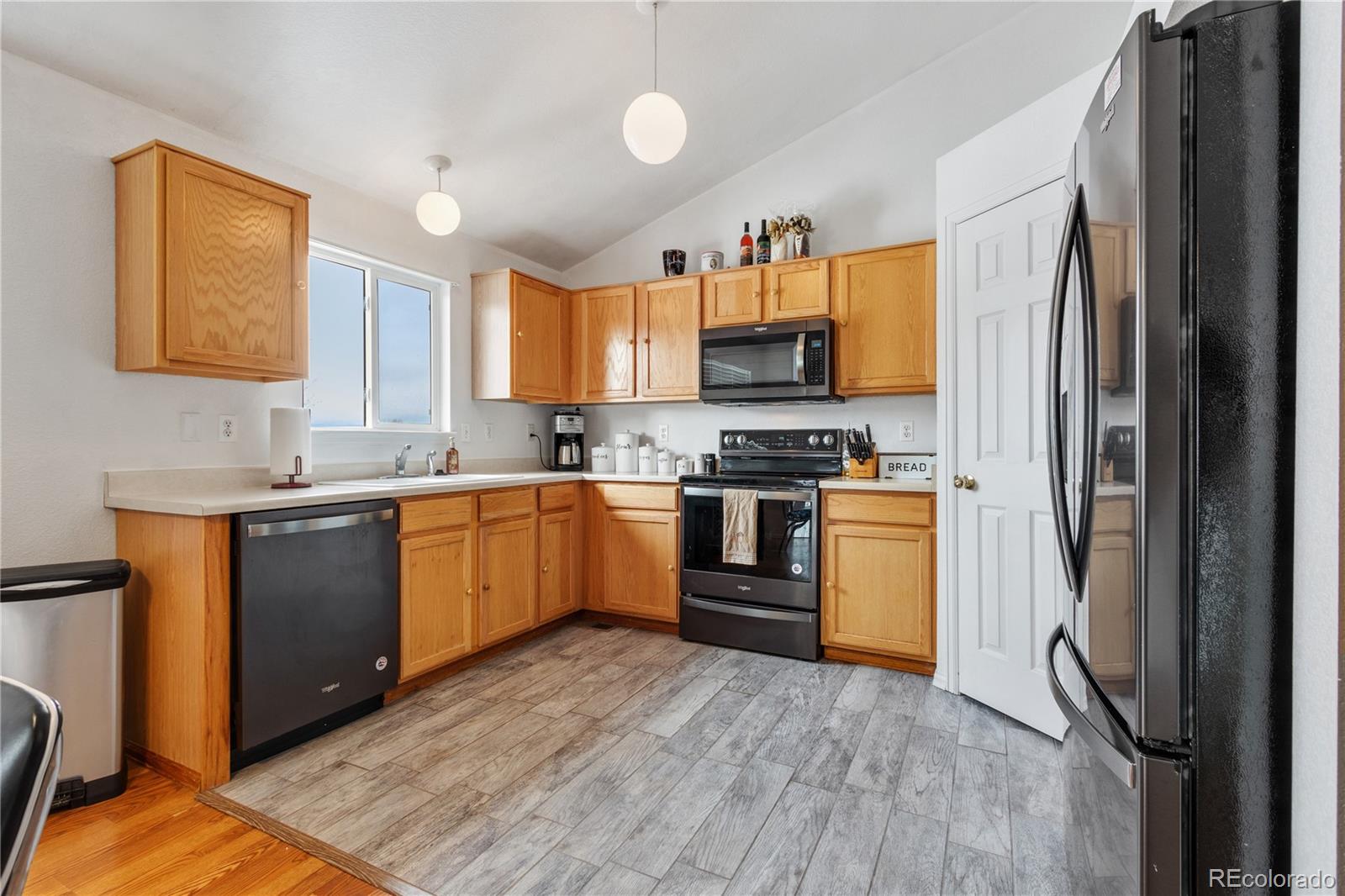5405 Wolf Street Frederick, CO 80504 - Photo 11 of 36 a kitchen with a sink appliances cabinets and a counter top space