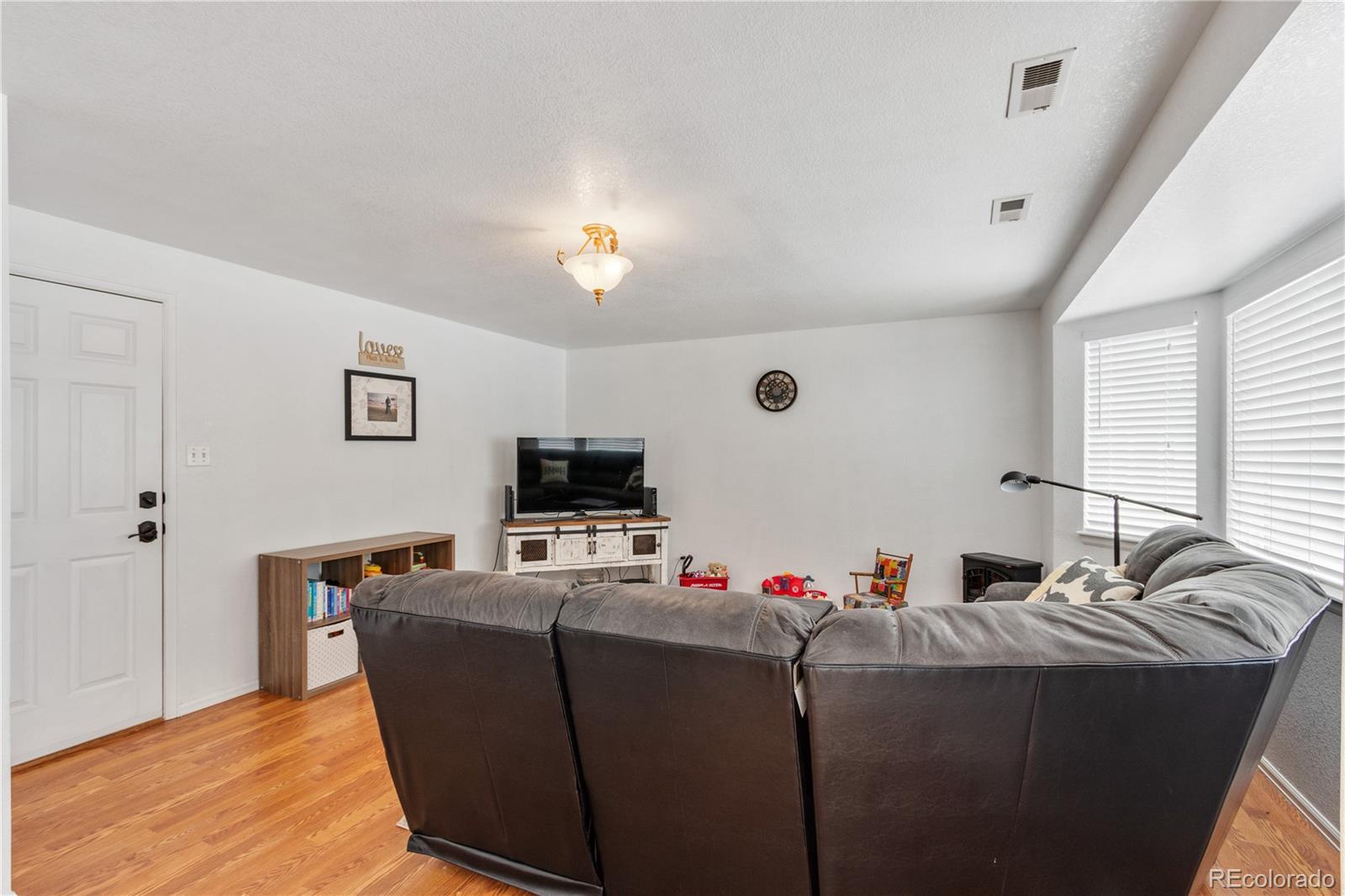 5405 Wolf Street Frederick, CO 80504 - Photo 14 of 36 a living room with furniture and a flat screen tv