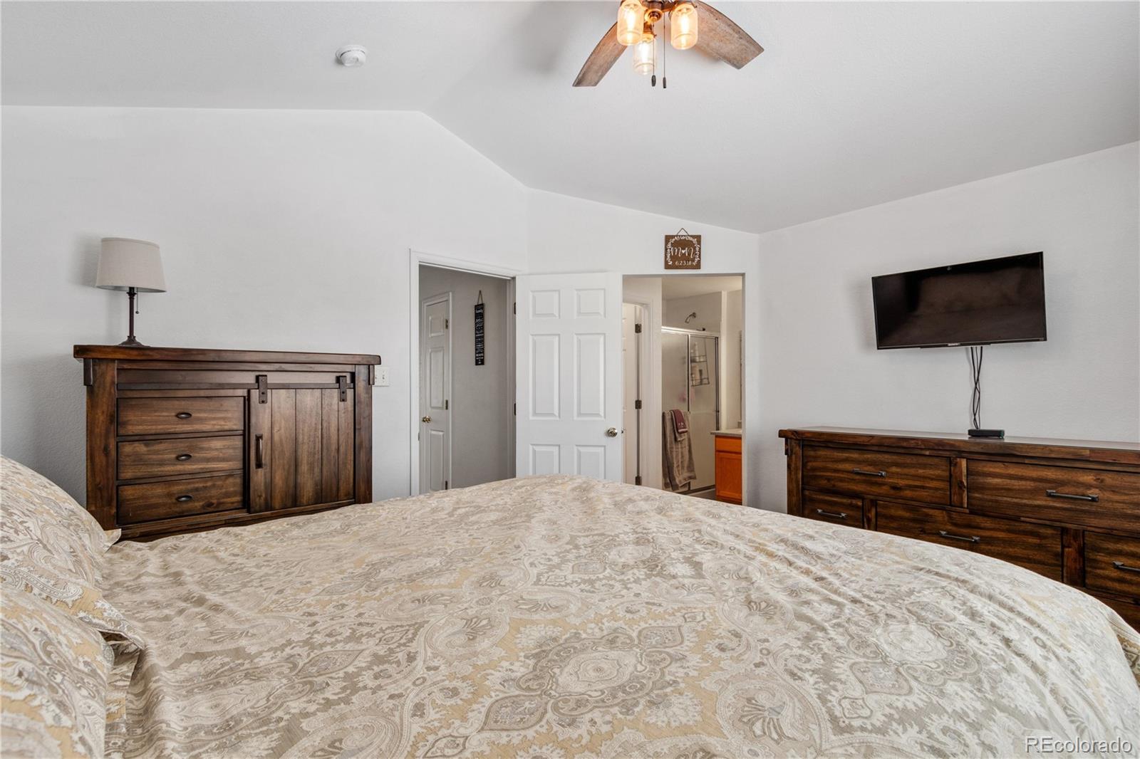 5405 Wolf Street Frederick, CO 80504 - Photo 19 of 36 a bedroom with a bed and a flat screen tv