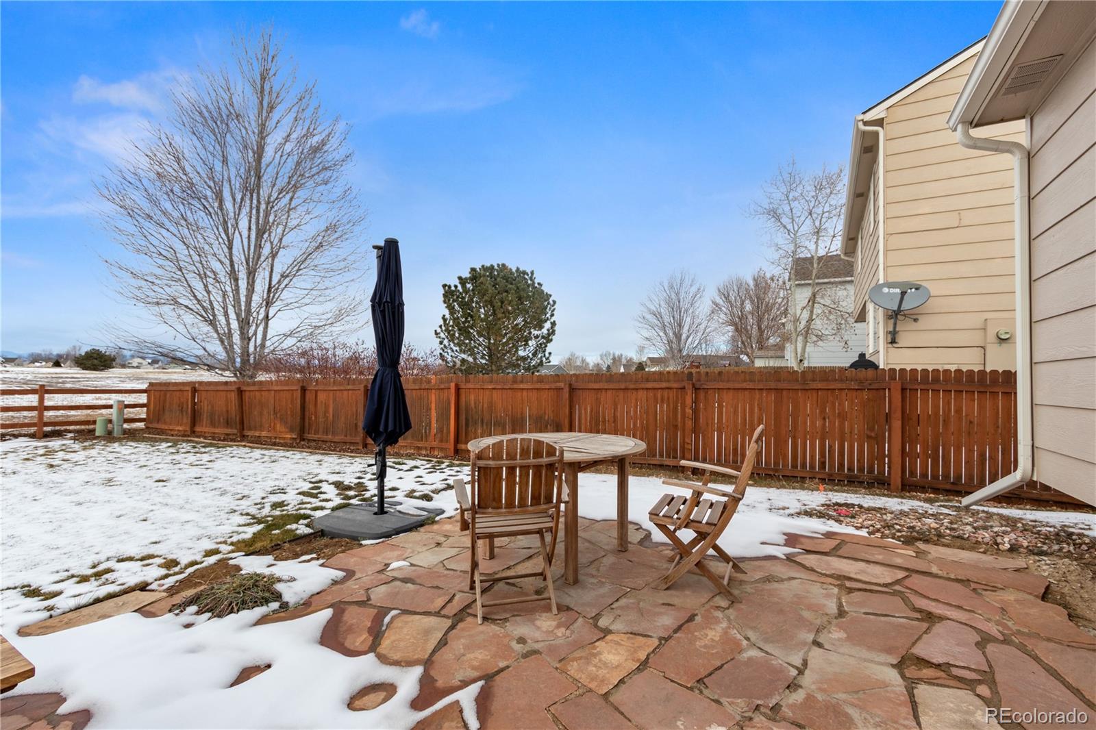 5405 Wolf Street Frederick, CO 80504 - Photo 30 of 36 a view of backyard with a table and chairs and wooden fence