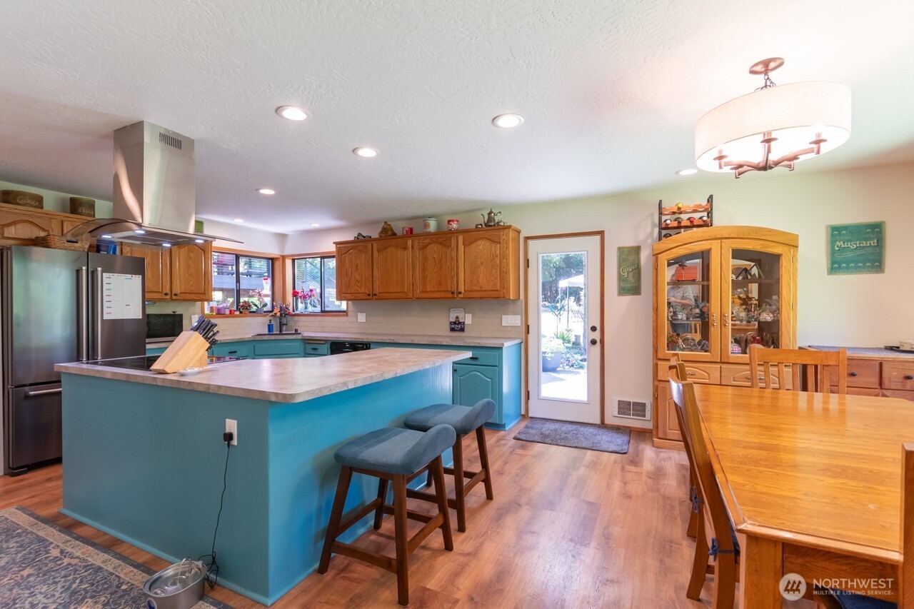 492 Walkabout Way Port Angeles, WA 98363 - Photo 15 of 40 a kitchen with stainless steel appliances kitchen island granite countertop a table chairs and a refrigerator