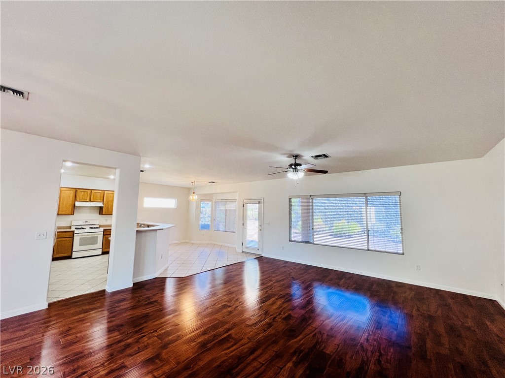 3047 Hickory Valley Road Henderson, NV 89052 - Photo 2 of 33 Rich hardwood flooring extends into a spacious living area, complemented by a convenient kitchen with an open layout.