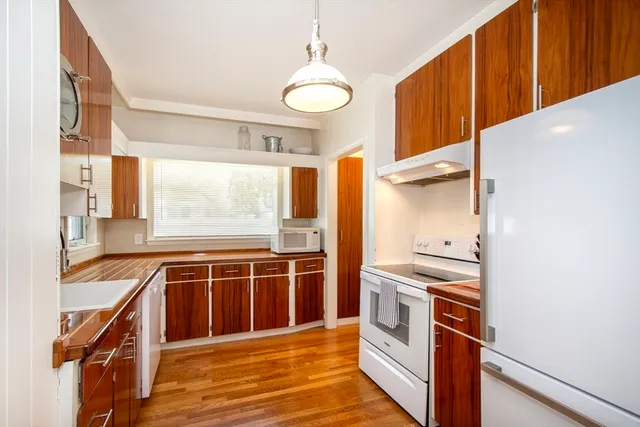 a kitchen with stainless steel appliances granite countertop a stove and a wooden cabinets