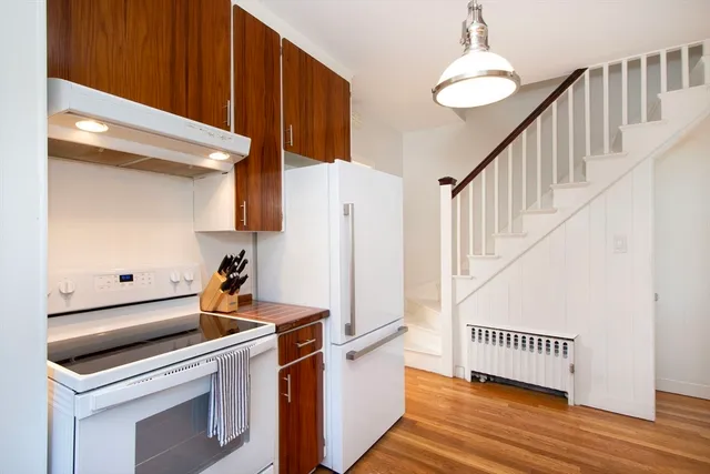 a utility room with wooden floor washer and dryer