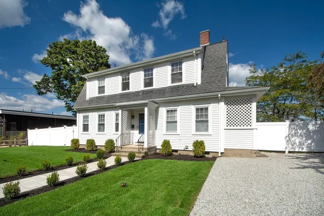 a front view of a house with a garden and plants