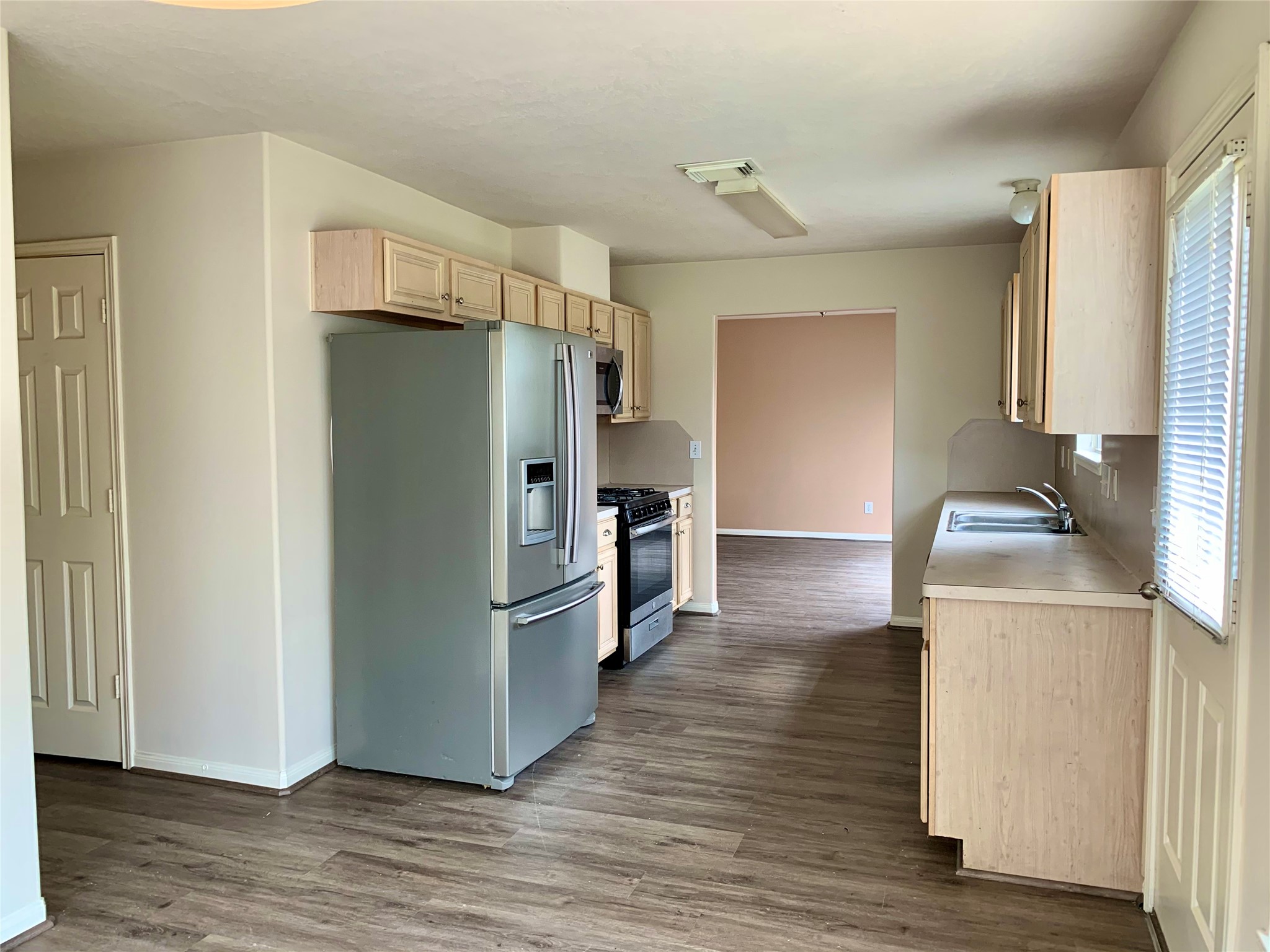 25203 Bluma Ranch Drive Katy, TX 77494 - Photo 8 of 26 a kitchen with a refrigerator sink and wooden floor