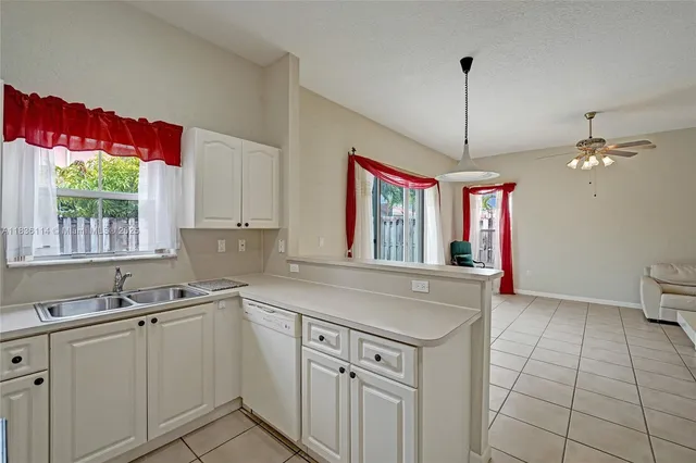 a kitchen with a sink window and cabinets