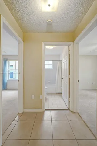 a view of a hallway to rooms and wooden floor