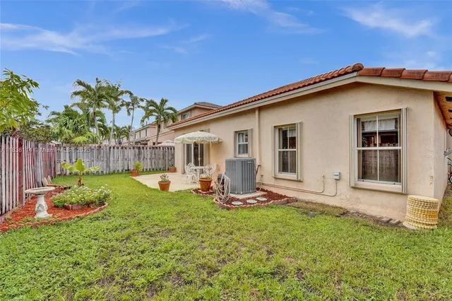 a view of a house with backyard sitting area and garden