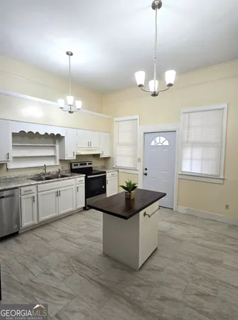 a kitchen with granite countertop stove and cabinets