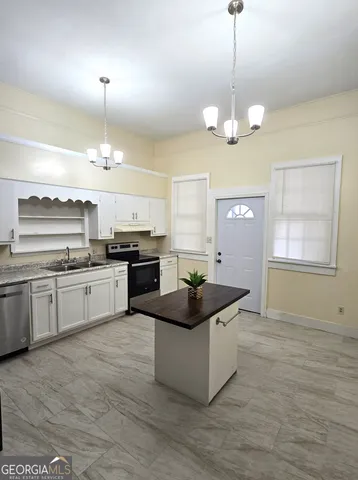 a kitchen with granite countertop stove and cabinets