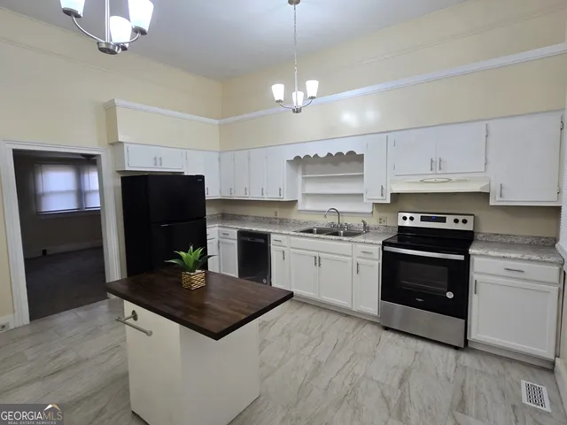 a kitchen with a sink a stove a microwave and cabinets