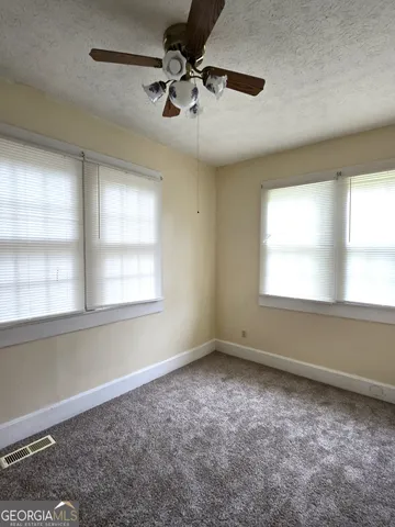 a view of room with a ceiling fan and window