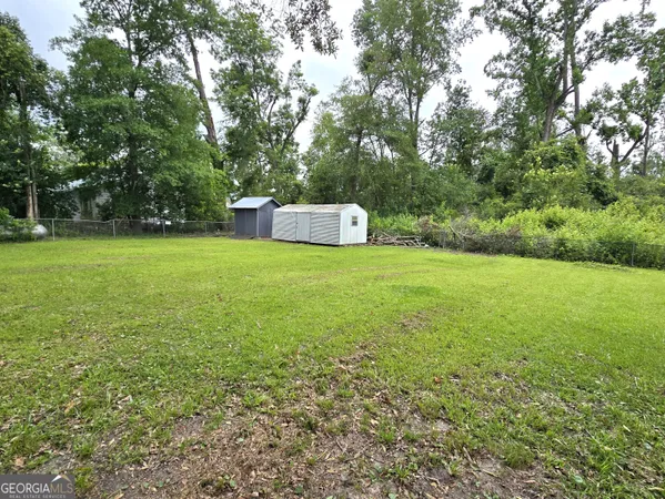 a view of a big yard with a house and large trees