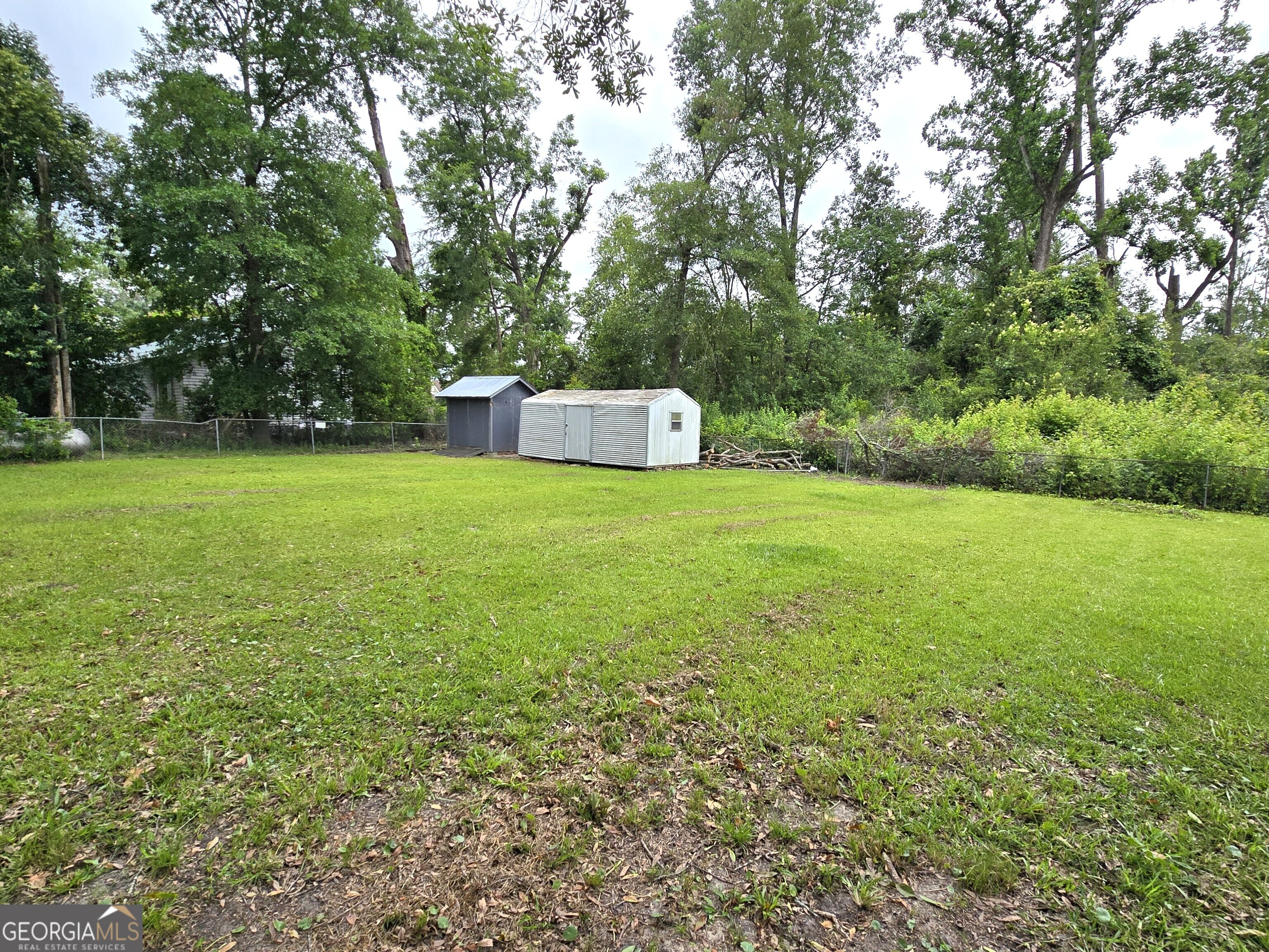 35 Cheatham Street Wadley, GA 30477 - Photo 5 of 18 a view of a big yard with a house and large trees