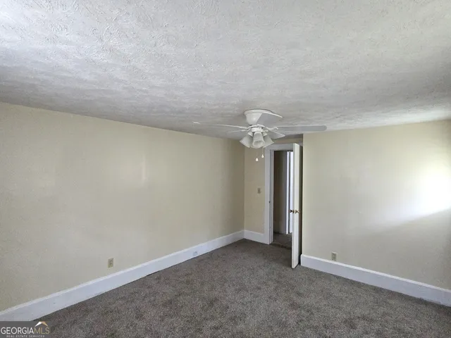 an empty room with chandelier fan