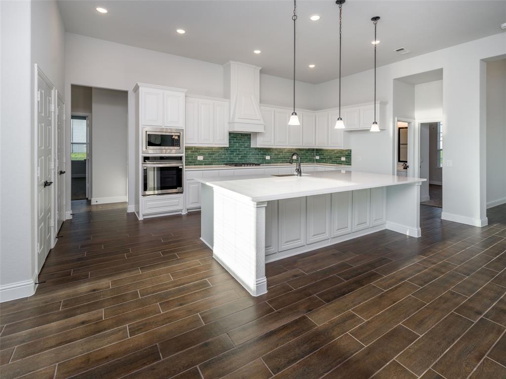 2108 Charters Circle Nevada, TX 75173 - Photo 12 of 37 Kitchen with white cabinets, appliances with stainless steel finishes, a spacious island, recessed lighting, and backsplash