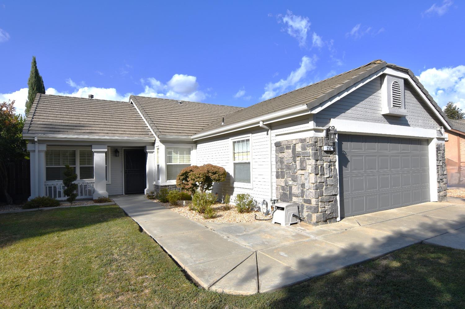 a front view of a house with a yard and outdoor seating