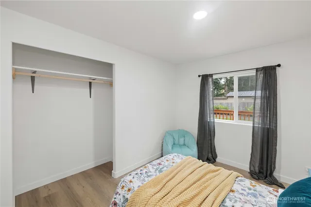 a bedroom with a bed and wooden floor