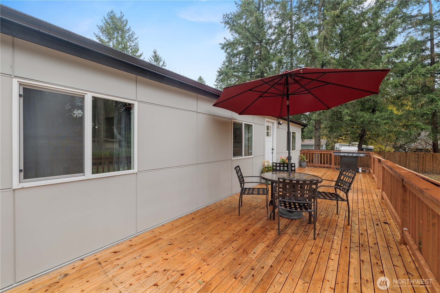 27428 Witte Road Southeast Maple Valley, WA 98038 - Photo 23 of 31 a view of a house with table and chairs under an umbrella